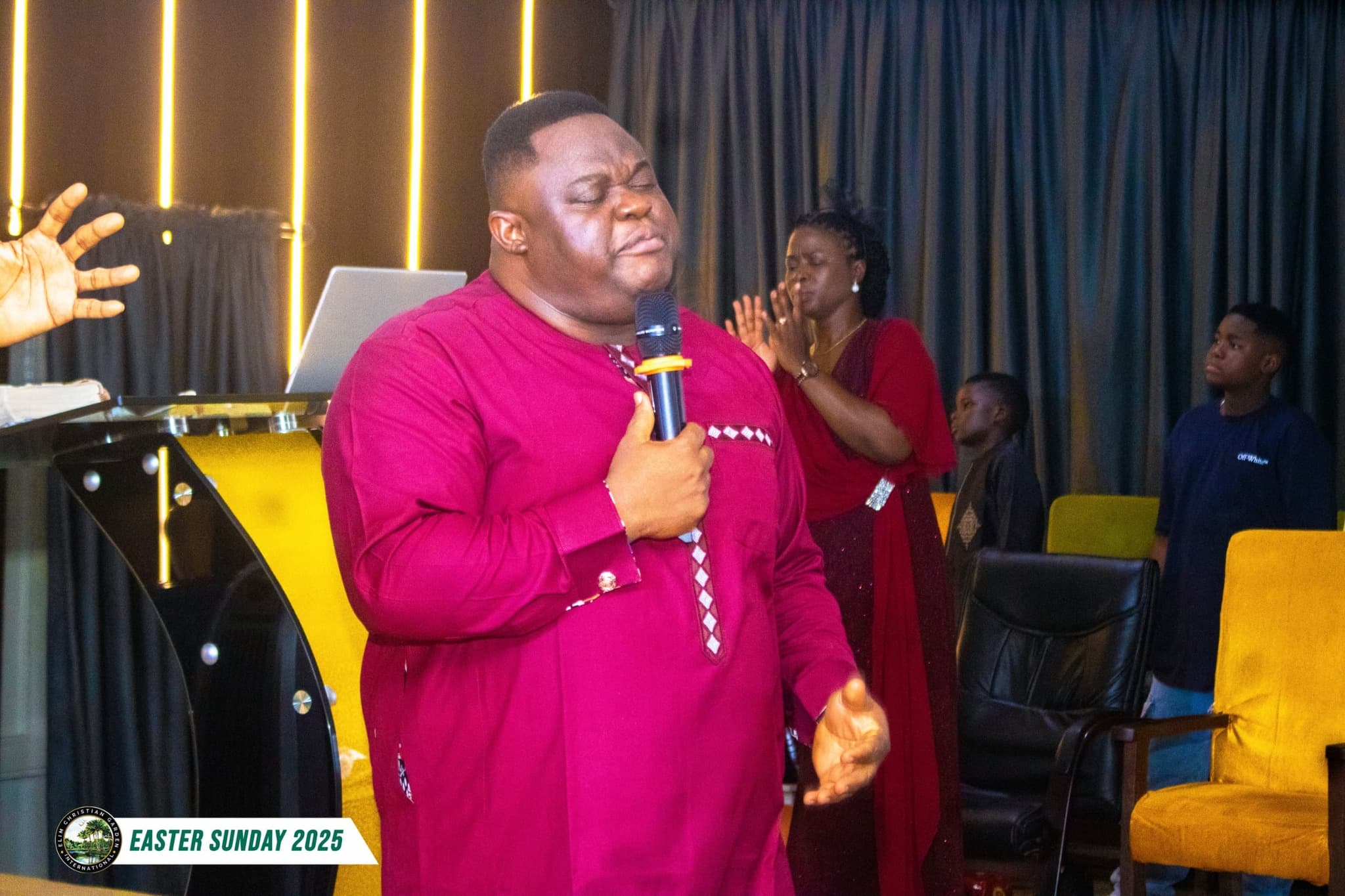 A minister leading worship at Elim Christian Garden